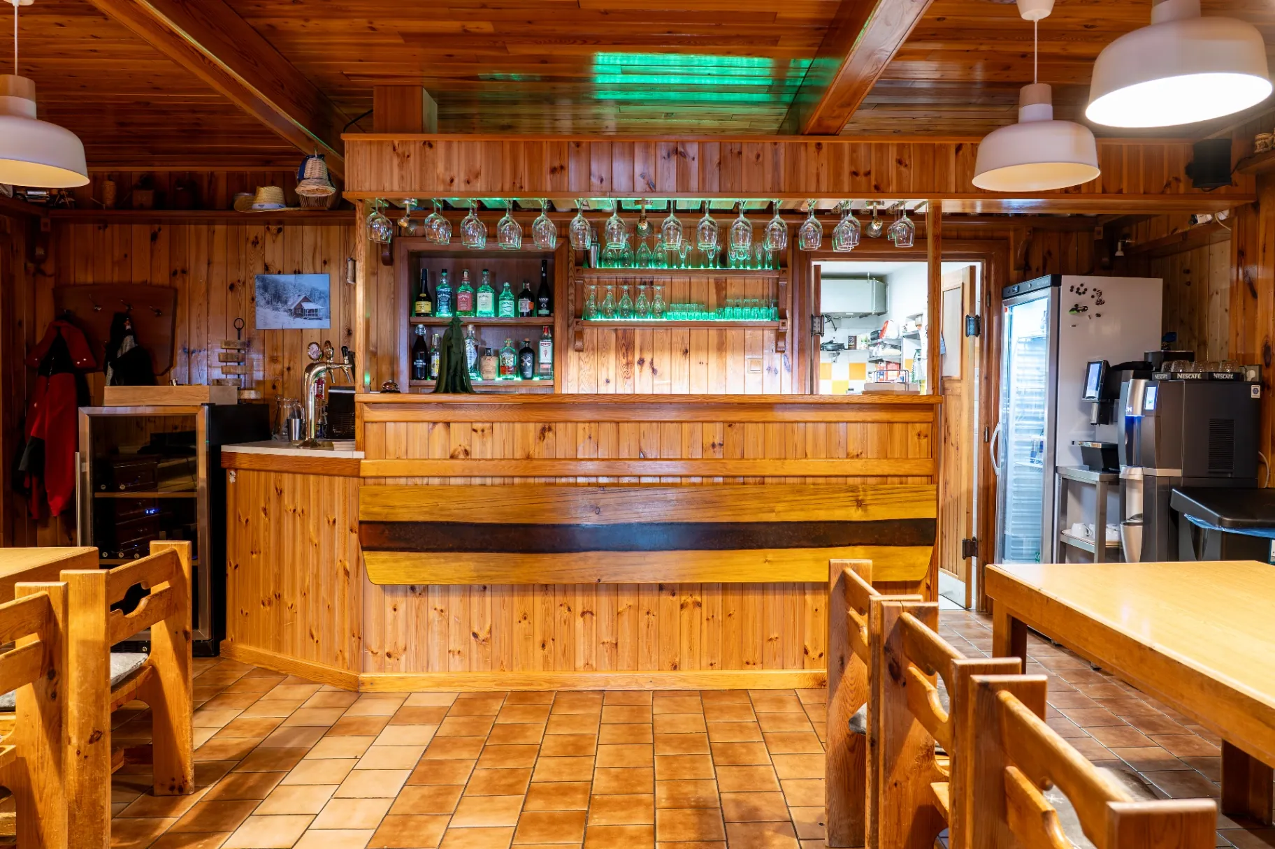 Dřevěný bar s pípou a sklenicemi ve společenské místnosti